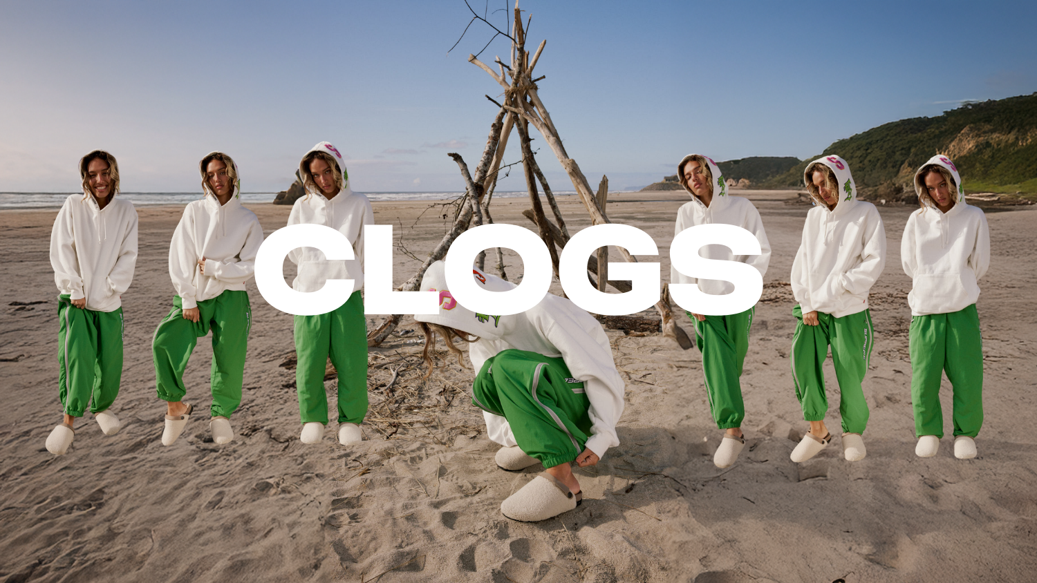 girl standing on the beach and squatting wearing bone colored fuzzy clogs. The word 'Clogs' is displayed in large text across the image.